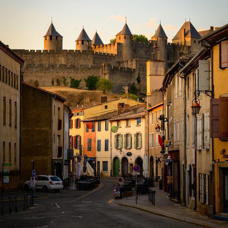 La Cité domine une rue aux façades colorées, à Carcassonne